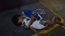 Un niño sin hogar se aferra a su perrito para darse amor y calor en el piso