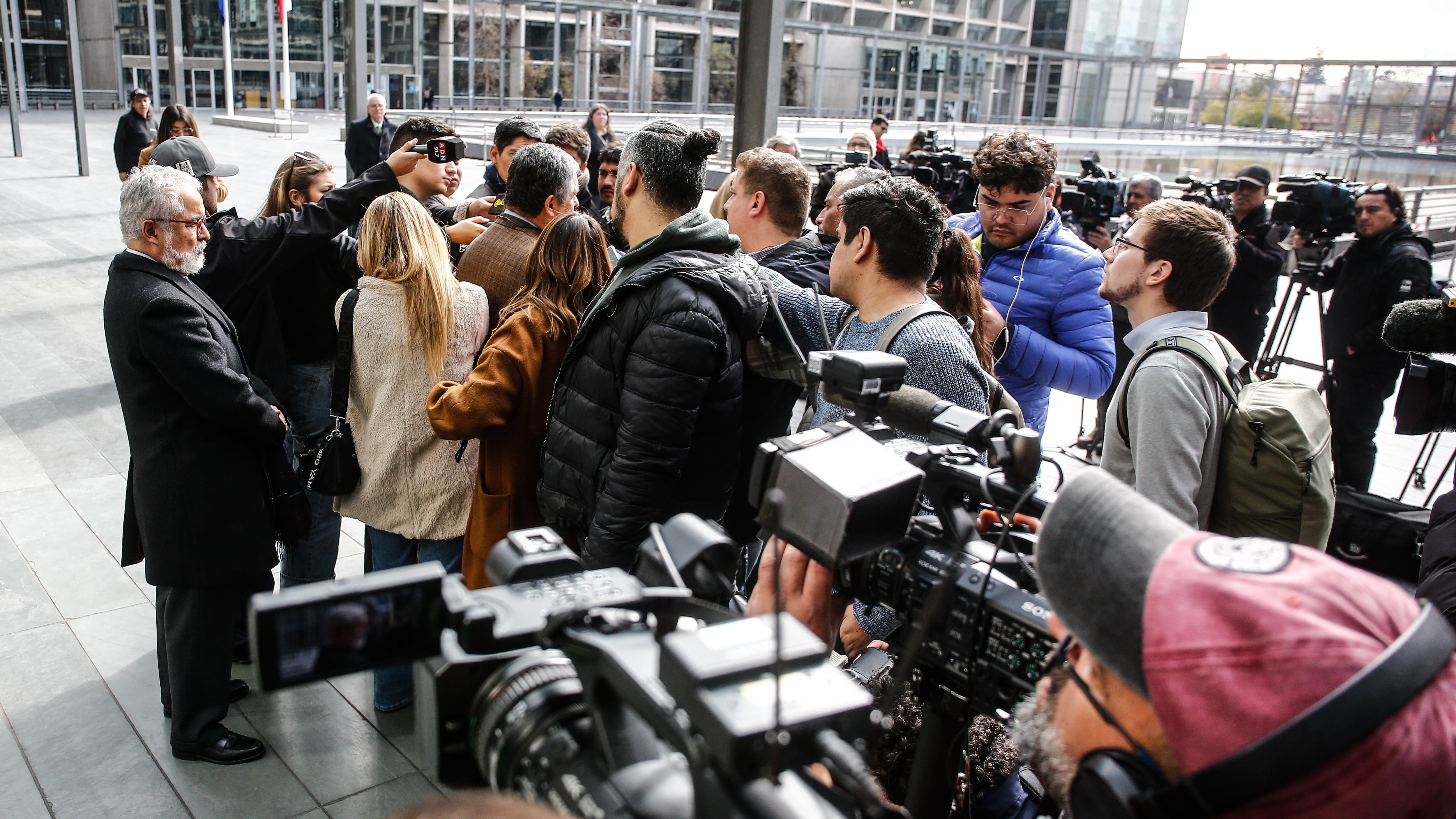 Hermosilla mira mientras su abogado responde a la prensa en el Centro de Justicia. / AGENCIA UNO