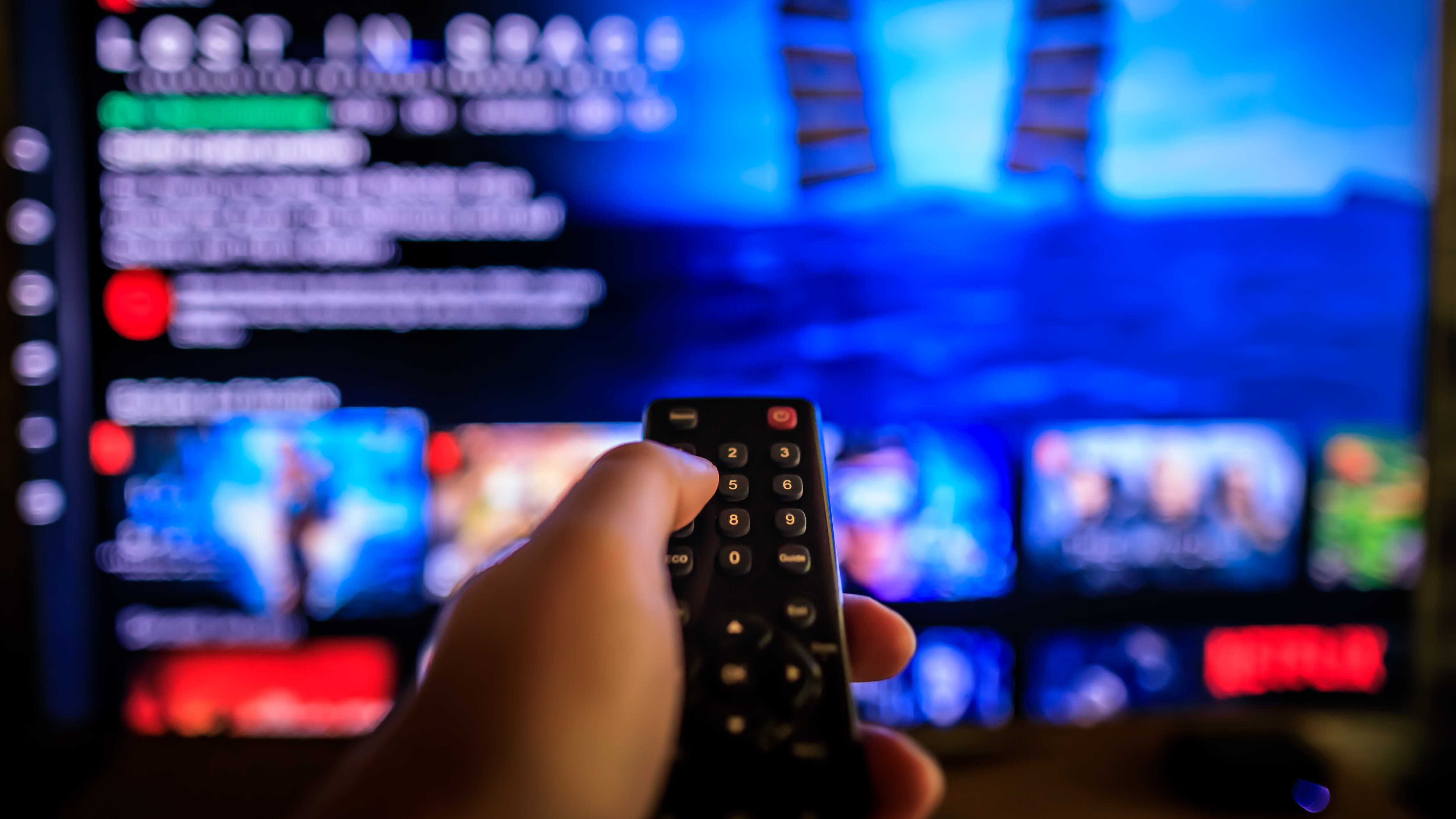 Una persona apunta al televisor con un control remoto.