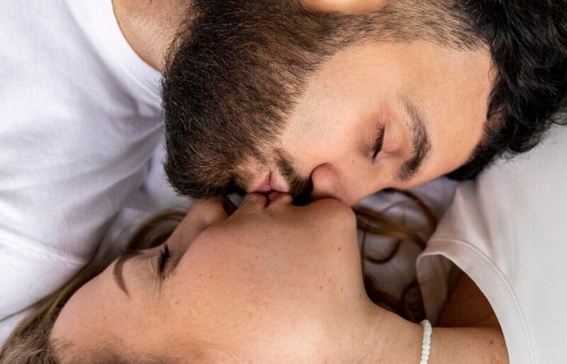 Pareja sonriente besándose en casa