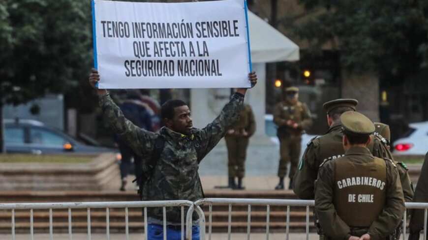 En horas de la mañana un ciudadano extranjero se instaló en las afueras del Palacio de La Moneda con cartel en mano, advirtiendo de tener una importante información que las autoridades debían conocer, porque puede afectar al país. 
“Tengo información sensible que afecta a la seguridad nacional”, tenía escrito en el lienzo que mostraba con las manos en alto.
Tras su intervención, al hombre se le permitió el ingreso a la Casa de Gobierno, donde fue recibido por el abogado de la ministra del Interior Carolina Tohá.
Según contó al medio Agencia Uno el motivo de su denuncia es por “una red de pornografía infantil y espionaje masivo que está sucediendo”, alcanzó a decir antes que carabineros le solicitara su cédula de identidad.  
Pero, aseguró que eso es “solo una parte, hay mucha más que esa”, la cual la dará a conocer en su totalidad cuando la reciba la secretaria de Estado.
“Todavía no me recibe la ministre, cuando la ministra me reciba yo le doy la información a ella. Me recibió el abogado de la ministra, debatimos unas cosas. Se está investigando una denuncia que yo puse hace tres meses sobre esta red y aún el fiscal tuvo alguna citación”.
“Les dije quiénes eran sus líderes, su modus operandi y cómo trabajaban y nunca me han llamado de la fiscalía y de ningún lado. Y la otra denuncia no la puse, porque si no me llamaron de esta qué voy a esperar de la otra”, dijo resignado. 
Sin embargo, agradeció que desde La Moneda lo han tratado “muy bien” y va a esperar que lo llamen para “entregar la información correspondiente a la ministra”.