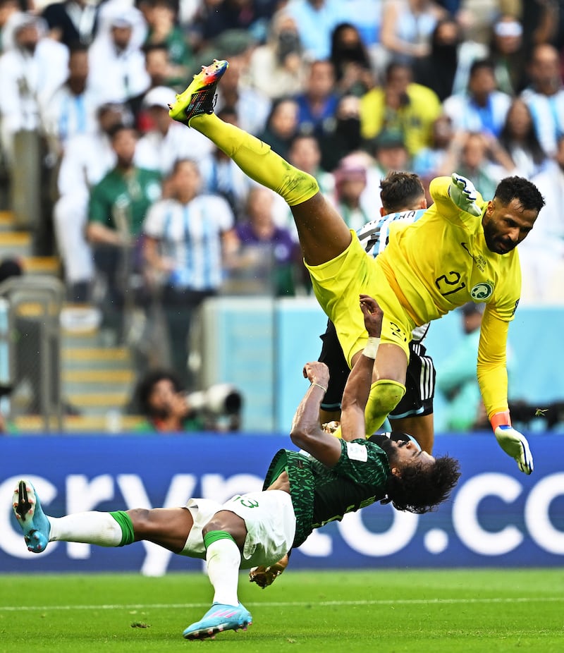 El portero de Arabia Saudita Mohammed Al-Owais (L) choca con su compañero de equipo Yasser Al-Shahrani (frente a la derecha) durante el partido de fútbol del grupo C de la Copa Mundial de la FIFA 2022 entre Argentina