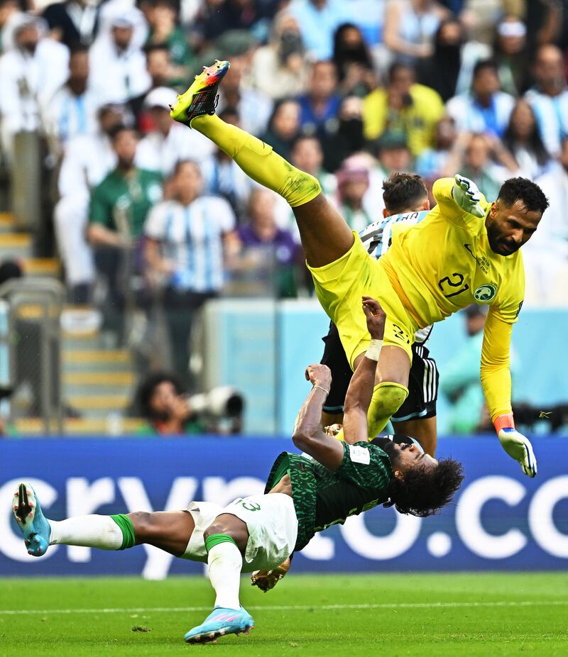 El portero de Arabia Saudita Mohammed Al-Owais (L) choca con su compañero de equipo Yasser Al-Shahrani (frente a la derecha) durante el partido de fútbol del grupo C de la Copa Mundial de la FIFA 2022 entre Argentina