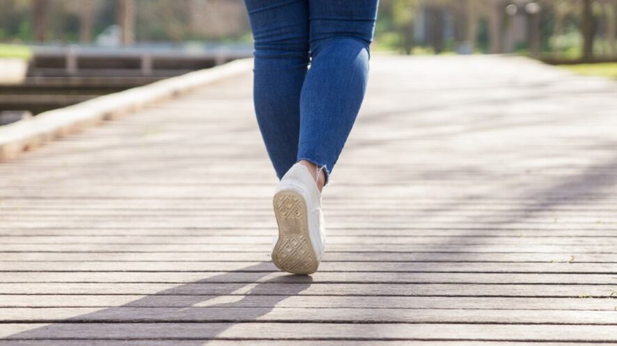Chica caminando por el sendero en el parque de la ciudad