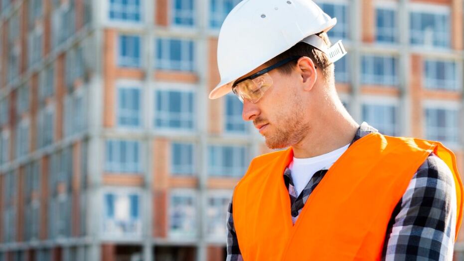 Ingeniero de construcción de la vista lateral del tiro medio que usa la tableta