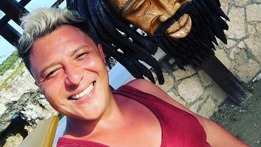 Sergio Rojas contó a Publimetro el ritual chamánico que realizó en Jamaica, con el fin de buscar protección espiritual y limpiar sus energías, de cara a su retorno a la televisión con el debut de Me Late por el canal de cable Zona Latina, el próximo 24 de junio.
Fue durante sus vacaciones familiares y la celebración de su cumpleaños en la isla de Bob Marley, que el periodista recurrió a unos sanadores locales, quienes, a punta de marihuana lo hicieron visualizar a sus “rivales” faranduleros. 
“Les explico que acá había mucha envidia, mucha gente en la televisión, como malula y le nombro a Daniela Aránguiz, Raquel Argandoña, Mauricio, Israel y ellos me hicieron fumar una marihuana que es de acá, por lo tanto quedas volado a los cinco segundos y te dicen que te enfoques en tu trabajo, en la gente que tú crees que te puede hacer daño”. 
En ese momento, Sergio Rojas acostado en el suelo y con los ojos cerrados, comienza a recibir la energía de los sanadores, quienes también estaban bajo los efectos curativos de la hierba. 
“Yo estaba tirado en el suelo, acá hay mucha tierra, las casas son muy básicas, entonces ahí estaba esta familia, que eran cinco personas y ellos también comienzan también a fumar marihuana, yo creo que están muy volados, más que uno y a través de un proceso de sanación, ellos como que te van a proteger de esas personas y de otros”. 
Visualizó a Raquel Argandoña
Fue ahí que Sergio Rojas comienza a visualizar a sus contrincantes televisivos, señalando que la imagen de Raquel Argandoña fue la que más le impactó. 
“Yo vi imágenes de personajes de la tele, veía mi nueva casa televisiva, gente de los otros programas como a Daniela, a Manu (González), a Hugo (Valencia),  a todos los que trabajan en el canal y también veía a personas con las que generalmente puedo tener algún tipo de inconveniente como Raquel Argandoña”.
“La imagen de Raquel era la más distorsionada, porque que era como una suerte de momia. Como que la vi muy cadavérica en esta lluvia de imágenes. Me quedó súper marcado, una imagen muy delgada, muy huesuda, como a acercándose y alejándose. Muy loco, muy loco”.
“En el fondo tu estás muy volado y ellos comienzan a bailar como unas danzas bien aborigen alrededor tuyo, fumando mucha marihuana. Y con unas ramas comienzan como a azotarte y gritan, bailan y todo”
Si bien, reconoció que no entendía los cantos ni las palabras que emitía la familia, dice haberse sacado un gran peso de encima.
“Quedé como súper liviano, full energía. Como que hubo una sacar mochilas y malas energías. Creo que con este ritual me enfrenté a los grandes demonios de la televisión y si logré salir de ahí, estoy preparado para todo. Este regreso será monumental”, sentenció.