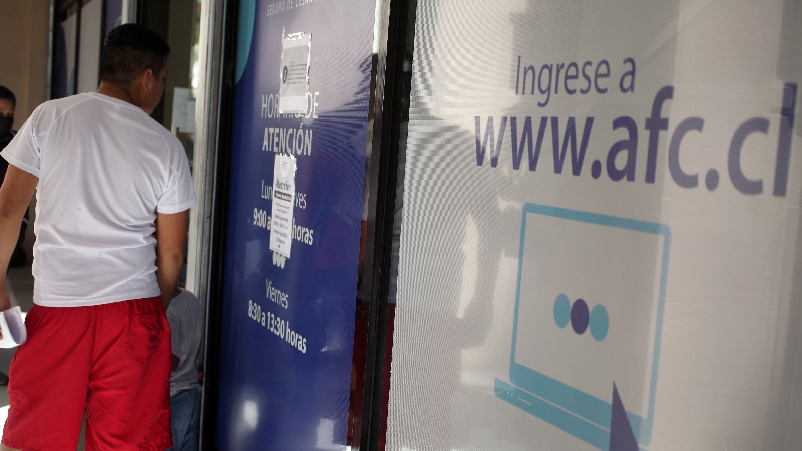 Personas esperando a las afueras de la sucursal de la AFC de la comuna de Santiago, ubicada entre las calles Agustinas y Teatinos, para cobrar su seguro de cesantía.