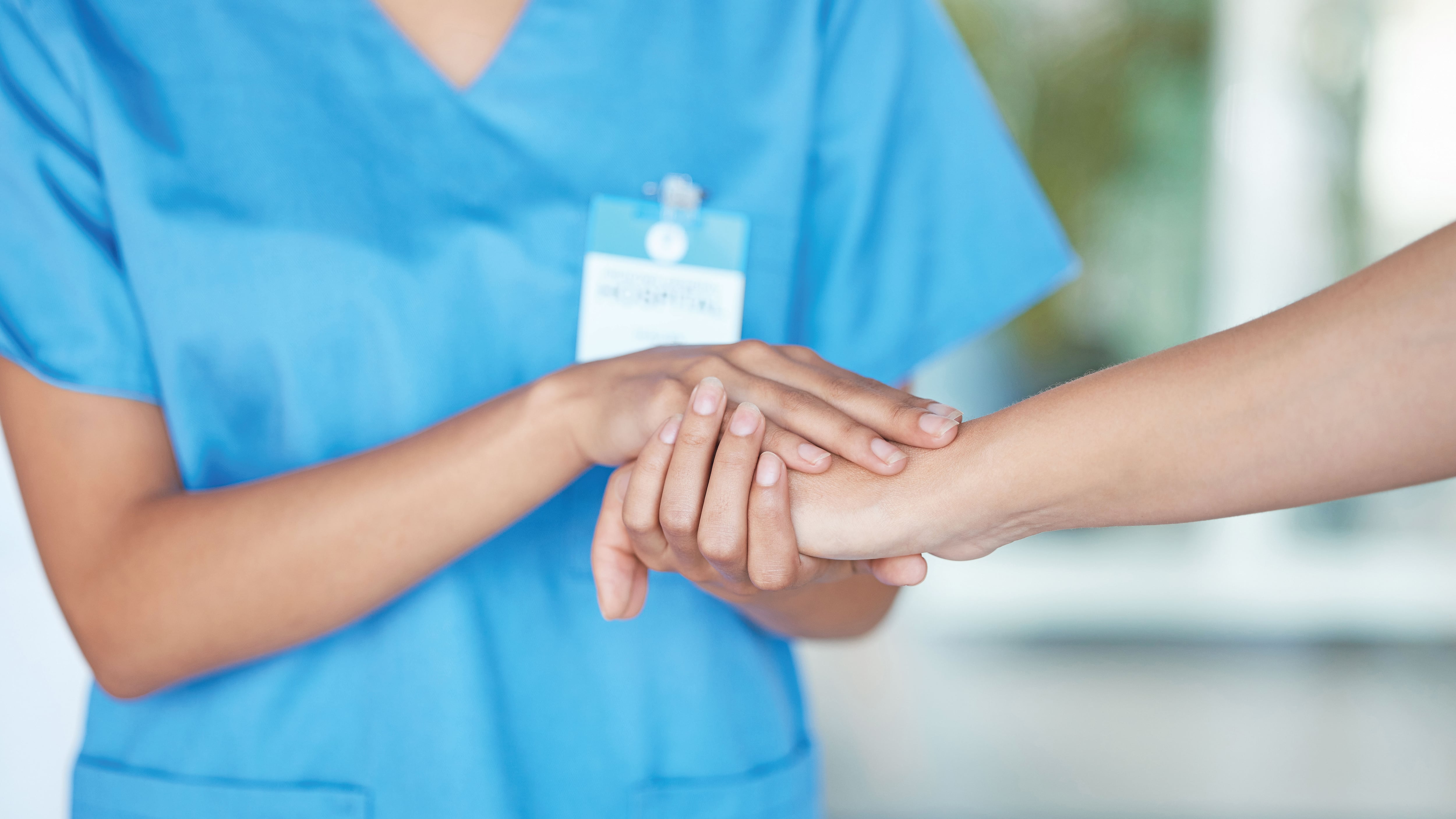 Enfermera agarra la mano de un paciente