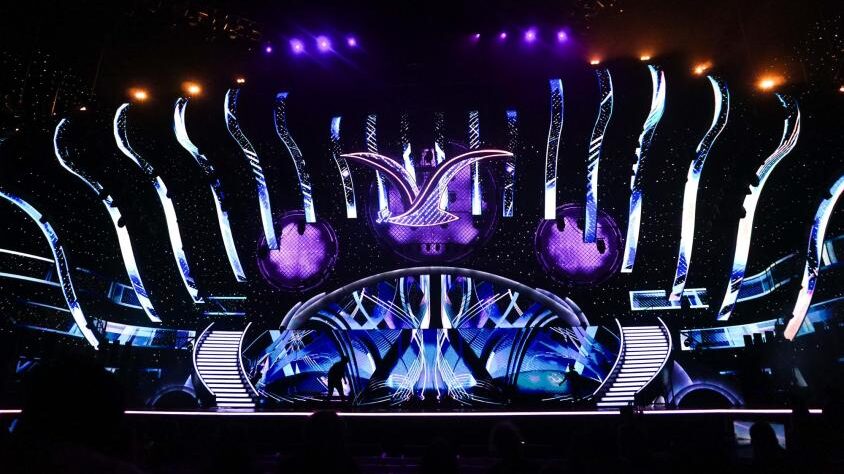 Este viernes 5 de abril se cierra el plazo para que los canales de televisión presenten sus ofertas para quedarse con la licitación del Festival de Viña del Mar, por los próximos cuatro años, desde el 2025 al 2028. Sin embargo, a un día del cierre, habrían más preocupación que interés por adjudicarse el certamen internacional.
Según reveló un reportaje publicado por el Diario Financiero el pasado 28 de marzo las nuevas bases que impuso el municipio de la Ciudad Jardín, no tendría para nada contento a las casas televisivas, puesto que aumentarían los costos de manera significativa. Esto, considerando que tampoco los canales auguran ganancias, sino que solo pérdidas económicas.
“No están los tiempos para apostar por un producto que no es rentable. Daniel Merino, el último productor general del evento, declaró a DF MAS en febrero que la instancia pierde entre $ 1.000 a $ 2.000 millones cada año”, se lee en el reportaje.
Cláusulas complicarían a canales de TV
Dentro de las nuevas clausulas, se critica la reincorporación de la gira promocional por América y/o Europa “la cual será financiada por el concesionario”.
“En esta gira, deberá contemplarse la participación de la Comisión Promoción Festival (involucrando al alcalde(sa), concejales, equipos técnicos municipales y representantes del concesionario)”.
Además, otra exigencia que generó recelo en los canales, fue la exigencia de los arreglos y remodelación de la Quinta Vergara.
“La mayoría de los canales considera injusto que sea responsabilidad del concesionario, tomando en cuenta que las estaciones de TV lo ocupan pocas semanas al año”.
Estas mejoras, incluyen “habilitación del anfiteatro y escenario...montacargas, ascensor, baños públicos, camarines, butacas, calderas...”.
“Quienes conocen las especificaciones técnicas aseguran que todas estas remodelaciones no “están ni cerca” de las UF 42.000 (unos $ 1.500 millones) que se contempla en la licitación para ‘obras de desarrollo’”, recalcaron en el citado medio.
Además, se critica que la forma en que se deben elegir los artistas internacionales, quienes deben ser propuestos con seis meses de anticipación, para que luego sea el municipio quién decida si lo acepta o no. Esto generaría un problema de logística, puesto que para poder proponerlo, primero deberían chequear la disponibilidad del cantante, lo que provocaría un conflicto en caso de ser rechazado por la autoridad de Viña del Mar.
Finalmente, tampoco ayudó en el interés de los canales, el término anticipado del contrato que puede realizar de manera unilateral el municipio, sin necesidad de indemnizar a los canales.
“Por decisión de la municipalidad ésta podrá ordenar el término anticipado del contrato, mediante el decreto alcaldicio correspondiente, cuando así lo aconsejen las necesidades de la institución, o cuando concurran situaciones de caso fortuito o fuerza mayor. El aviso sobre el particular deberá ser comunicado por escrito al concesionario con una anticipación de 10 días corridos a que se produzca el término del contrato. Esta decisión no dará derecho a ningún tipo de indemnización”.