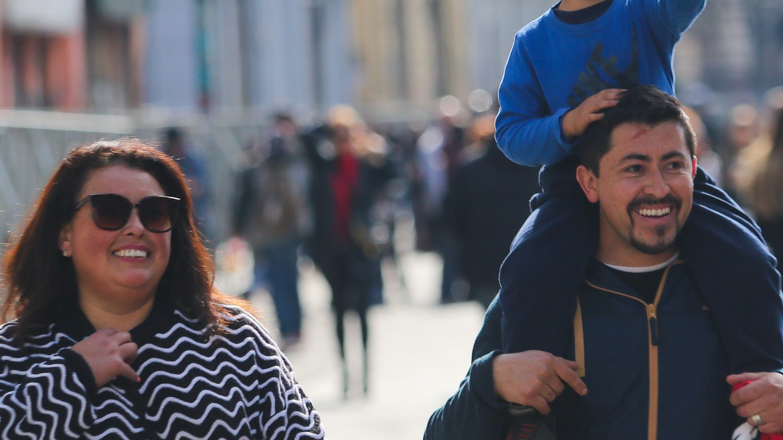 Una familia observa el desfile, en el marco de la Ceremonia del 145 aniversario del Combate Naval de Iquique y día de las Glorias Navales, donde participaron más de dos mil efectivos de la Armada, el Ejército, la FACH y Carabineros.