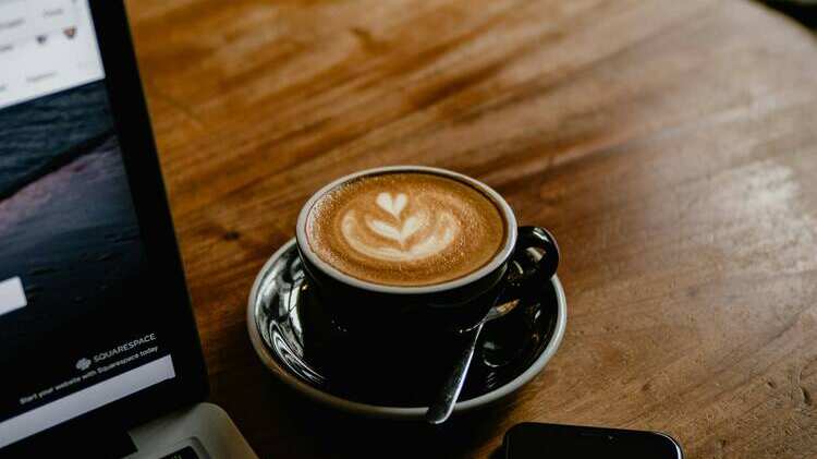 Imagen referencial de un café y un notebook