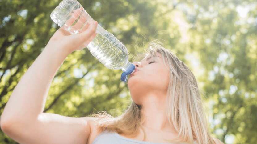 Vista inferior chica deportista bebiendo agua