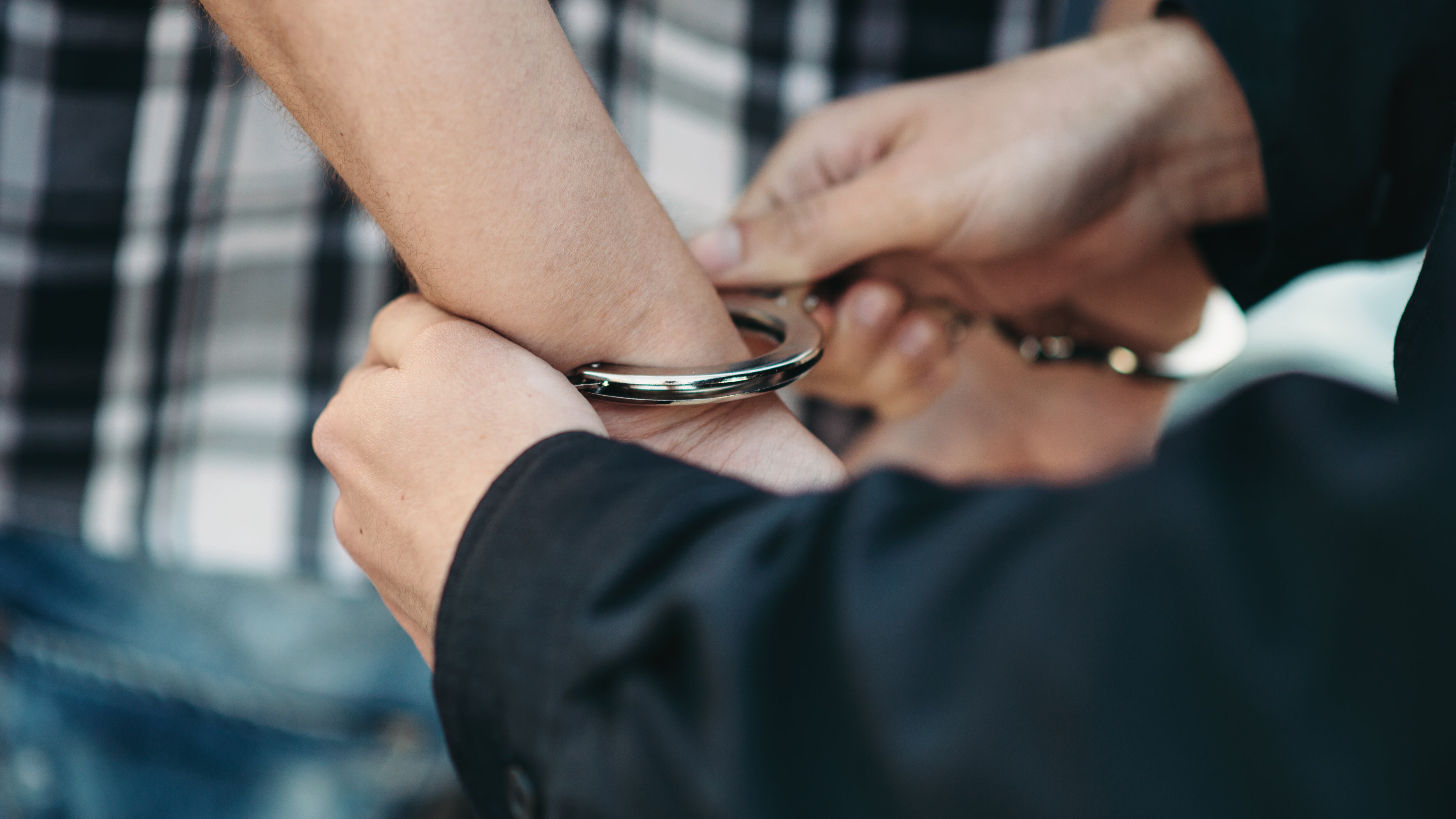 Un policía esposa a un ladrón de coches