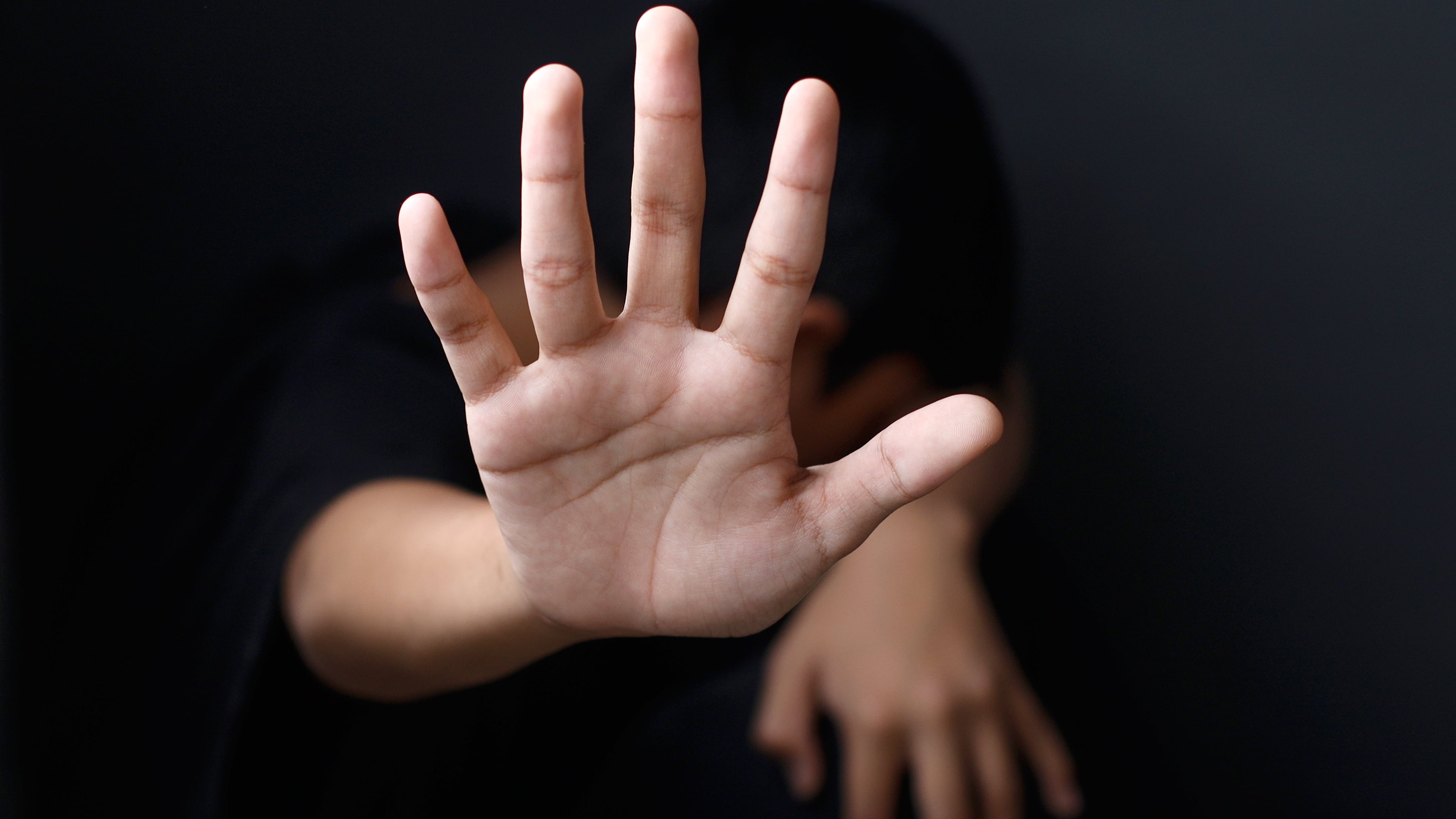 Primer plano de la mano de un niño haciendo el gesto de parar.