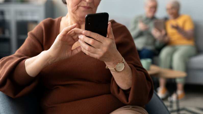 Adulta mayor con celular | Fuente: Freepik