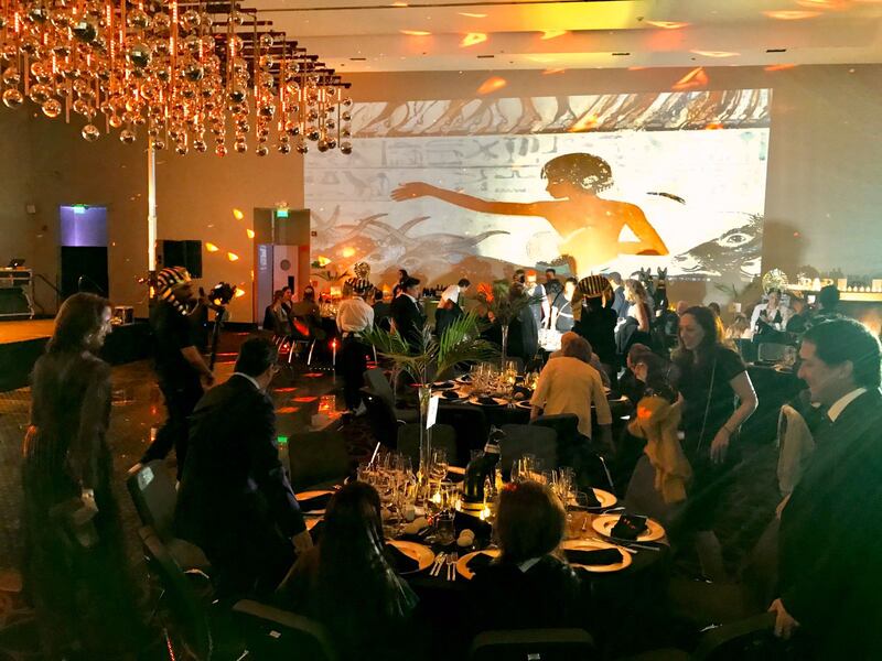 Fue una celebración a todo trapo, donde literalmente tiraron la casa por la ventana, o más, bien, el salón del Hotel W. Así lo definió el periodista Manu González, uno de los 100 invitados que llegaron al exclusivo evento para celebrar los 50 años de Kenita Larraín. Glamorosa fiesta inspirada en Egipto.
“Nos citaron a las 7:30 de la tarde. Bajabas al piso menos tres y según llegabas te recibían unas mujeres que te hacían un baile árabe. Era el recibimiento y te indicaban a qué salón tenías que acudir”, relató el panelista de Zona de Estrellas a Publimetro.
“Toda la temática de la noche era de Egipto. Te recibían dos chiquillos con los torsos desnudos y las máscaras de Anubis (guardián de las tumbas). Varios sarcófagos, con una mujer caracterizada como Cleopatra y un set de maquillaje donde te hacían el ojo y peinados”, agregó el español.
“A las 9:30 pasamos al salón principal. En la entrada nos recibió María Eugenia. Estaba con su hija y con su marido y familia. Era todo bien cabalístico. Diez mesas, cada una para 10 personas”, señaló.
Además, según reveló contó el periodista, las sorpresas comenzaron al principio de la noche, puesto que tanto su hija como su marido le tenían algo especial.
Tras cantarle el cumpleaños feliz, la pequeña sacó desde un estuche unas argollas y se las entregó a su padre para que renovara los votos con Kenita, con quien lleva ocho años casado.
“Sergio (Ader) le pidió renovación de votos y le entregaron un nuevo anillo ‘igual, pero diferente’”, relató Manu, sobre el momento que consideró el más emotivo de la velada.
El Menú
El menú fue de tres tiempos, destacando un mousse de queso de cabra con jamón curado y reducción de vino tinto.
De plato principal, carne traseada con salsa de cerveza y miel. Puré de zanahoria rostizada y relish de choclo.
Finalmente, de postres, mousse de avellana y baileys y pavlona.