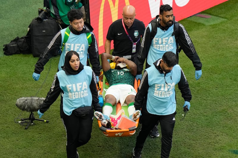 Los paramédicos llevan a Yasser Al-Shahrani de Arabia Saudita en una camilla durante el partido de fútbol del grupo C de la Copa Mundial entre Argentina y Arabia Saudita