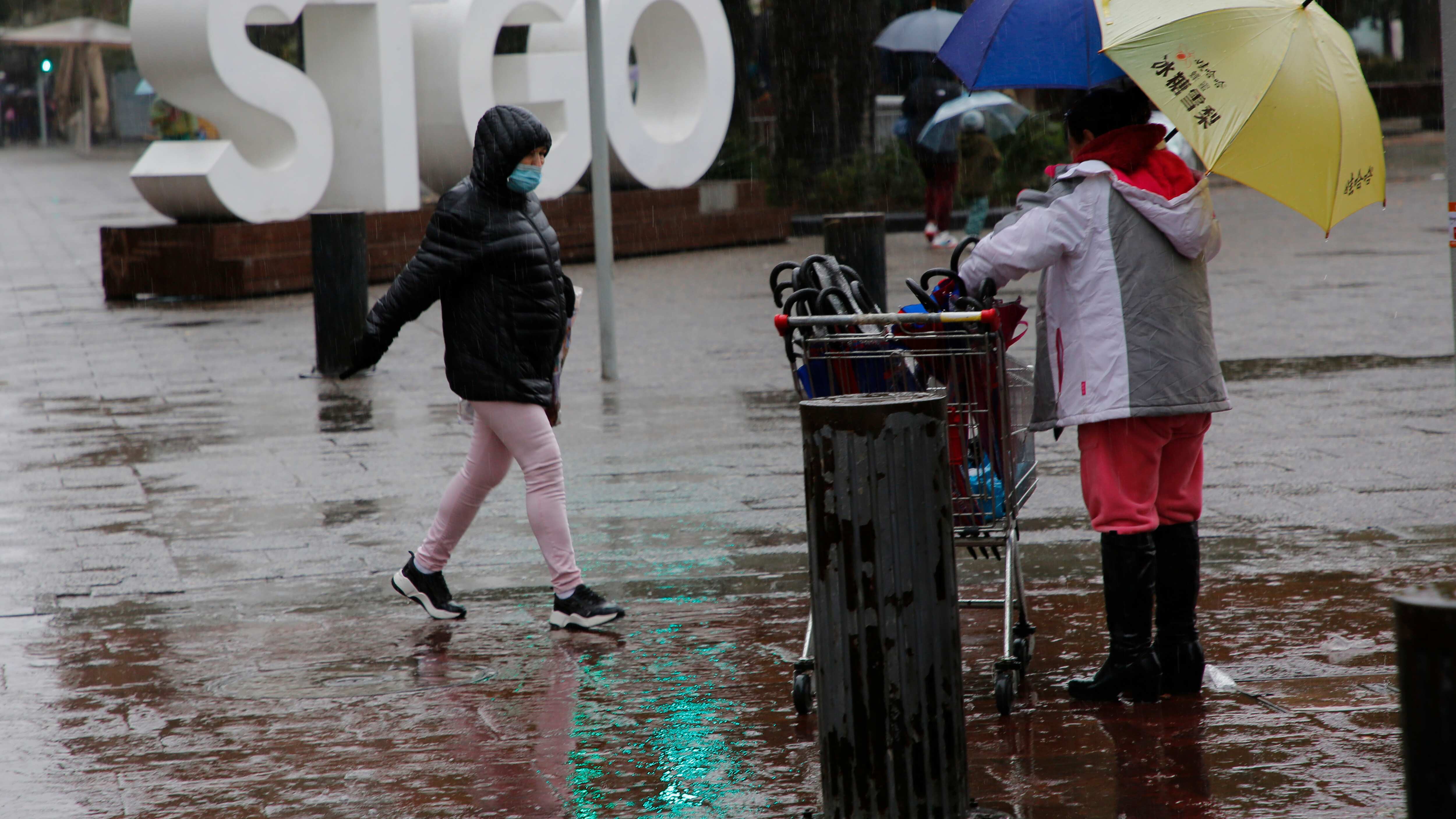 Santiaguinos son fotografiados durante las precipitaciones de este fin de semana.