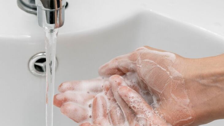 Persona de alto ángulo lavándose las manos en un fregadero