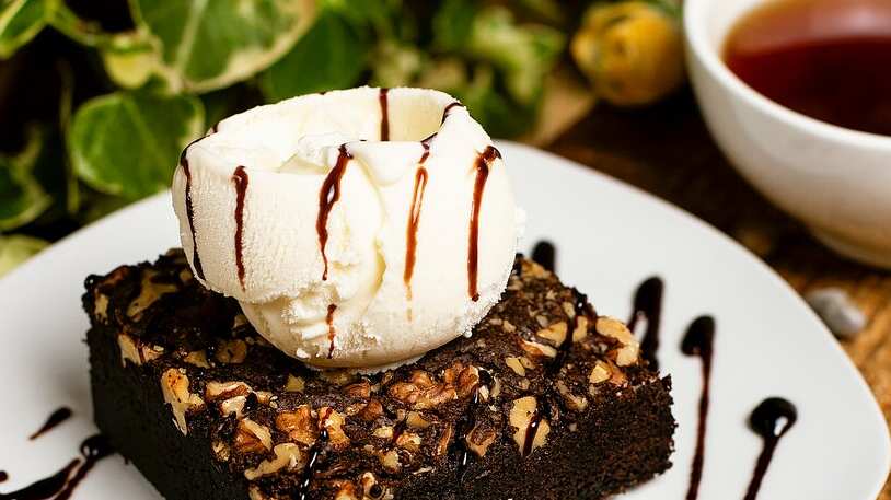 Una rebanada de brownie de chocolate con helado de nuez y vainilla.
