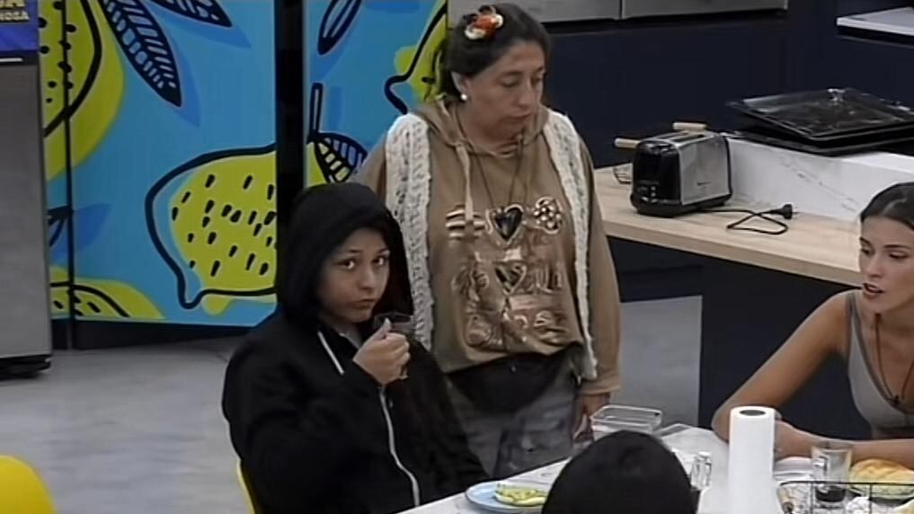 La participante de Gran Hermano Viviana Acevedo se declaró en rebeldía tras perder la prueba del líder frente a Scarlette Gálvez y generó la molestia de la producción del programa al hacer caso omiso a las órdenes que le daba la voz en off.
Todo ocurrió cuando los integrantes estaban en el comedor y Gran Hermano le pidió a Vivi que se colocara el micrófono.
Ahí, Sacarlette le pasó el banano con el equipo que se encontraba en otra silla, pero Viviana lo dejó a un lado y no se lo colocó.
Tras ello, se escuchó por los parlantes una nueva orden para que se colocara el micrófono, pero otra vez se negó e hizo un gesto a la cámara.
Producto de su rebeldía, Gran Hermano perdió la paciencia y le mandó al confesionario. Pero, al futbolista de Arica seguía comiendo el pan y tomando café como si nada.
Ahí la voz en off entró en cólera y le reiteró la orden, pero esta vez subiendo la intensidad.
“Viviana al confesionario, ¡ahora!”, le dijo por última vez antes de cortar la señal de Pluto TV.
Al perder la prueba del líder, al ser descalificada por sacar sus manos de la cabeza cuando hacían equilibrio, Viviana quedó en placa de eliminación junto a Cony, Pincoya, Jorge y Sacarleth.
Por este motivo, lo más probable es que Vivi pueda ser la nueva eliminada el próximo domingo, al recibir menor cantidad de votos positivos del público.